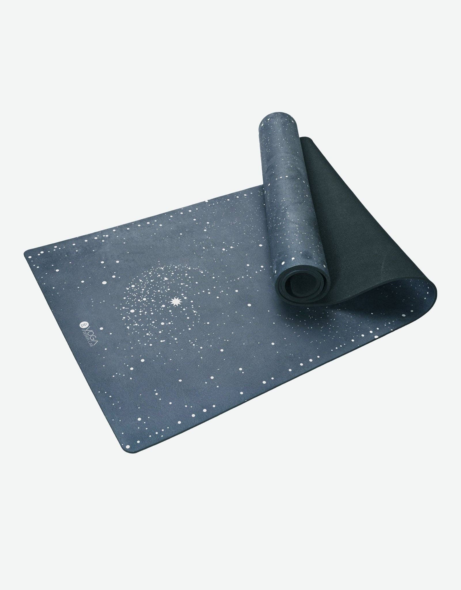 Dark gray yoga mat with star pattern on a white background