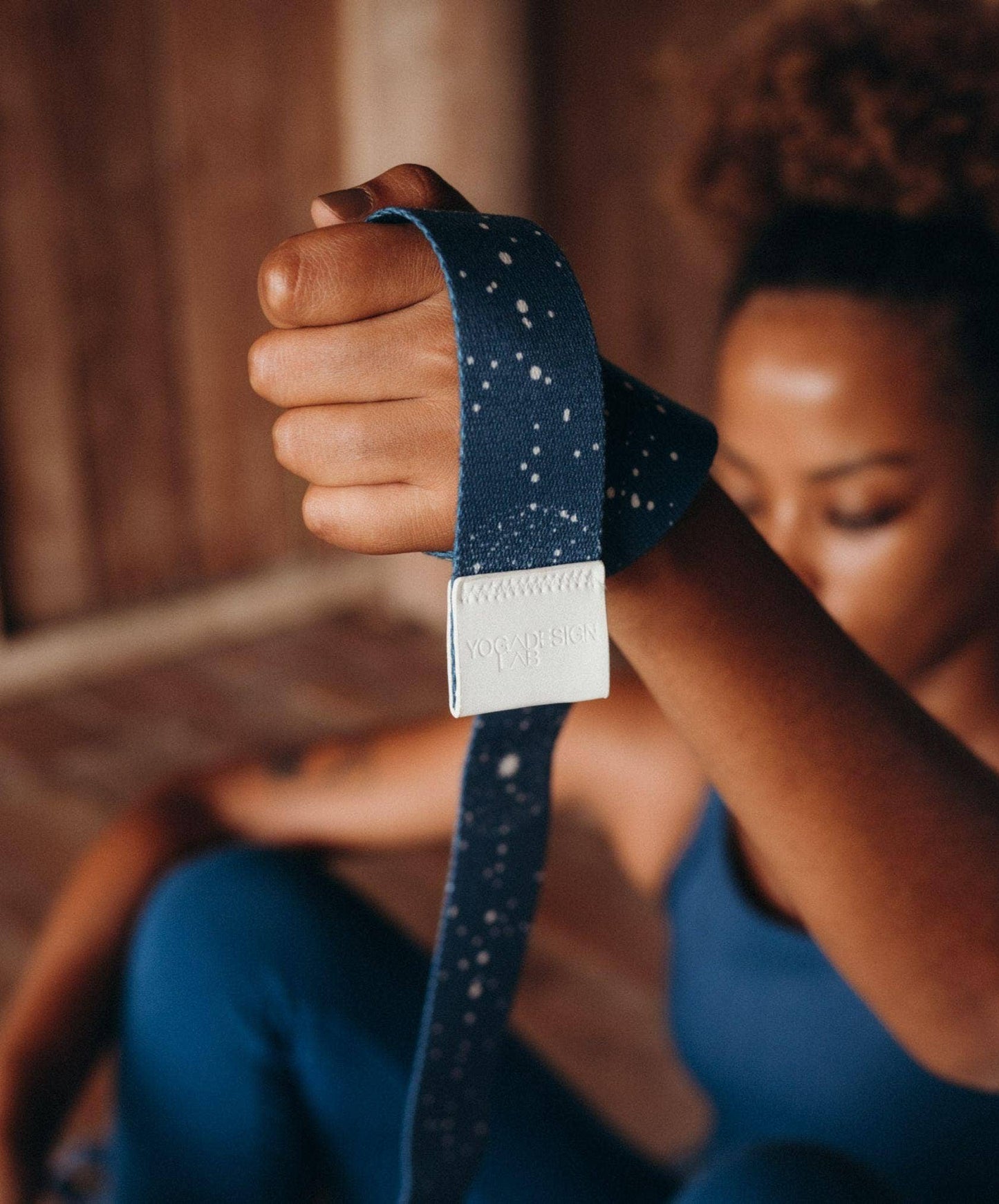 Person holding a blue yoga strap with a blurred background